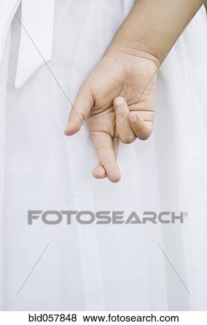 Stock Photo - Mixed Race girl with fingers crossed. Fotosearch