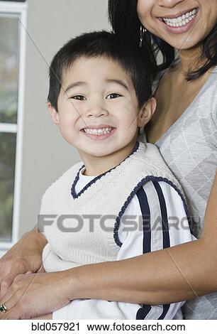 Mixed Race mother and son hugging View Large Photo Image Stock Image - Mixed Race mother and son hugging. Fotosearch