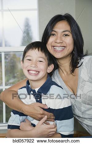 Mixed Race mother and son hugging View Large Photo Image Stock Image - Mixed Race mother and son hugging. Fotosearch