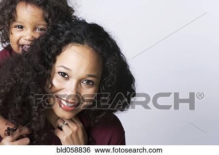 Mixed Race mother giving son piggy back ride View Large Photo Image Stock Photograph - Mixed Race mother giving son piggy back ride. Fotosearch