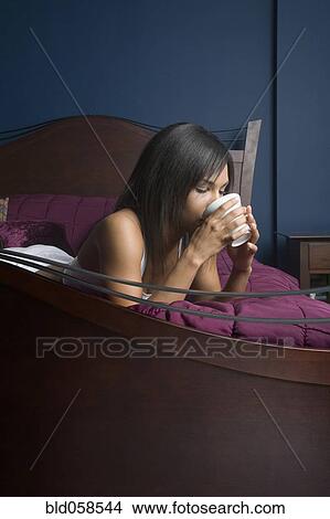 Picture - Mixed Race woman drinking coffee. Fotosearch