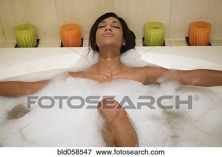 Stock Photo - Mixed Race woman relaxing in bubble bath. Fotosearch