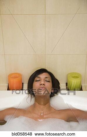 Stock Photo - Mixed Race woman relaxing in bubble bath. Fotosearch