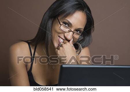 Stock Image - Mixed Race woman wearing eyeglasses. Fotosearch