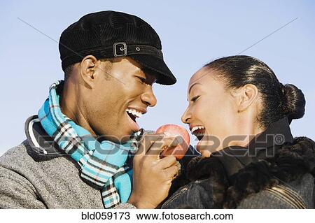 Multi-ethnic couple eating apple View Large Photo Image Stock Image - Multi-ethnic couple eating apple. Fotosearch