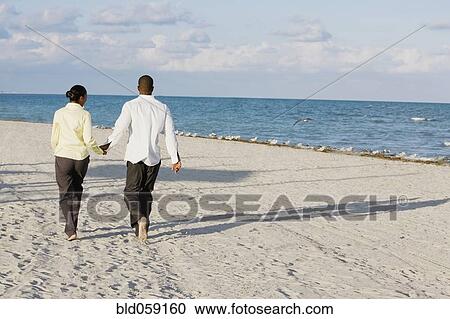 Stock Image - Multi-ethnic couple holding hands. Fotosearch