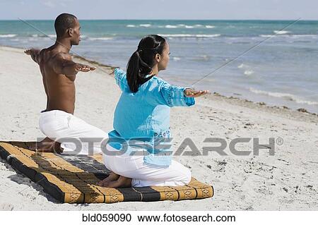 Stock Image - Multi-ethnic couple practicing yoga. Fotosearch