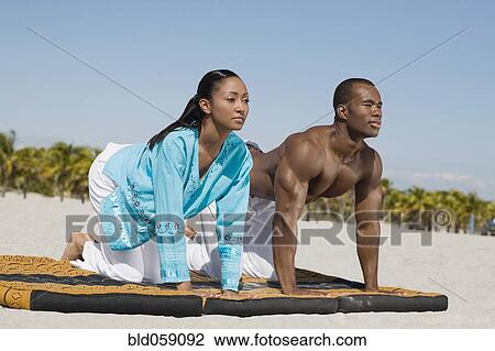 Multi-ethnic couple practicing yoga View Large Photo Image Stock Image - Multi-ethnic couple practicing yoga. Fotosearch
