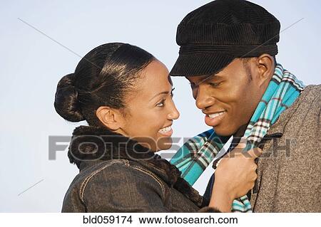 Multi-ethnic couple smiling at each other View Large Photo Image Picture - Multi-ethnic couple smiling at each other. Fotosearch