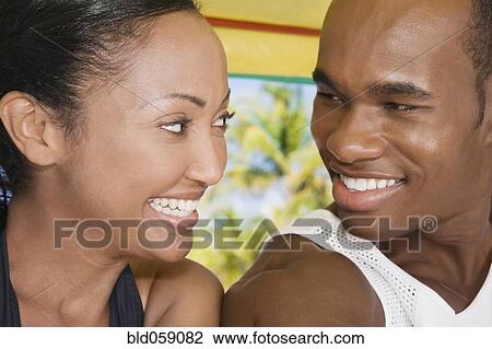 Stock Image - Multi-ethnic couple smiling at each other. Fotosearch