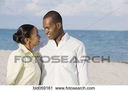 Multi-ethnic couple smiling at each other View Large Photo Image Stock Image - Multi-ethnic couple smiling at each other. Fotosearch