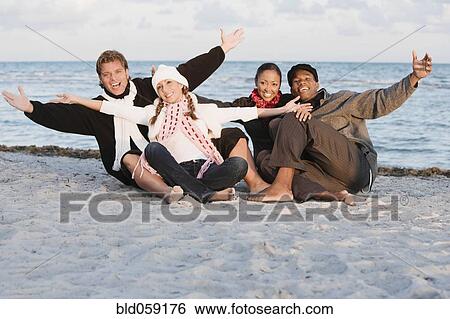 Multi-ethnic couples sitting on beach View Large Photo Image Stock Photograph - Multi-ethnic couples sitting on beach. Fotosearch