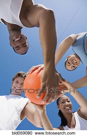Multi-ethnic friends holding volleyball View Large Photo Image Stock Image - Multi-ethnic friends holding volleyball. Fotosearch
