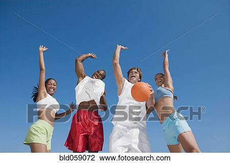 Multi-ethnic friends jumping with volleyball View Large Photo Image Stock Image - Multi-ethnic friends jumping with volleyball. Fotosearch
