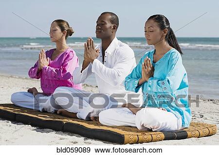 Stock Photo - Multi-ethnic friends meditating. Fotosearch