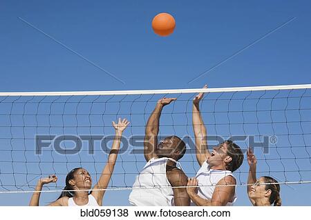 Multi-ethnic friends playing volleyball View Large Photo Image Stock Photo - Multi-ethnic friends playing volleyball. Fotosearch