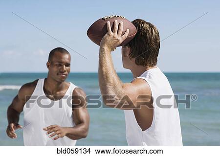 Picture - Multi-ethnic men playing football. Fotosearch