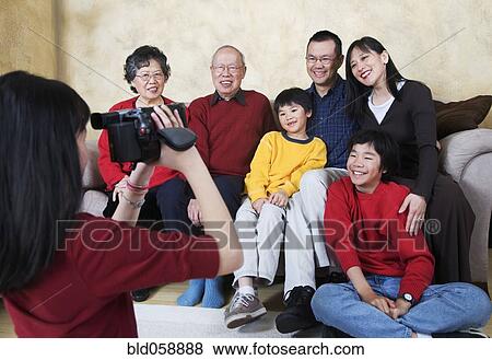 Stock Photo - Multi-generational Asian family being video recorded. Fotosearch