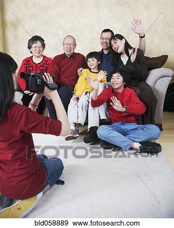 Stock Photo - Multi-generational Asian family being video recorded. Fotosearch