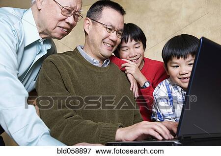 Multi-generational Asian family looking at laptop View Large Photo Image Stock Photo - Multi-generational Asian family looking at laptop. Fotosearch