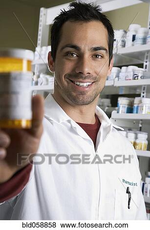 Pacific Islander pharmacist holding medication bottle View Large Photo Image Stock Photo - Pacific Islander pharmacist holding medication bottle. Fotosearch