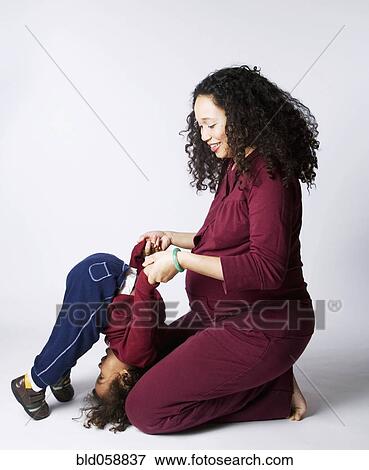 Pregnant Mixed Race mother playing with son View Large Photo Image Stock Photo - Pregnant Mixed Race mother playing with son. Fotosearch