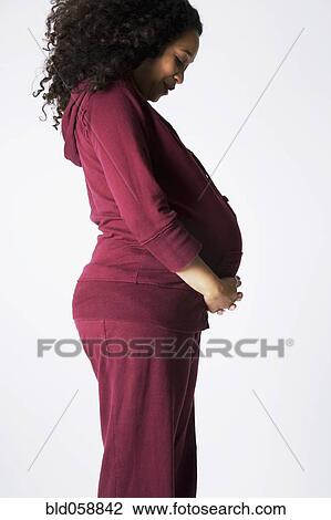 Pregnant Mixed Race woman looking at belly View Large Photo Image Stock Image - Pregnant Mixed Race woman looking at belly. Fotosearch