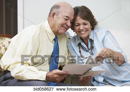 Senior Hispanic couple looking at photographs View Large Photo Image Stock Photo - Senior Hispanic couple looking at photographs. Fotosearch