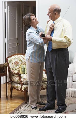 Senior Hispanic woman adjusting husband’s necktie View Large Photo Image Stock Photograph - Senior Hispanic woman adjusting husband’s necktie. Fotosearch