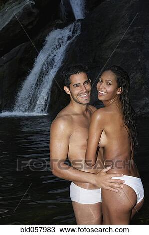 Stock Image - Topless Hispanic couple hugging. Fotosearch