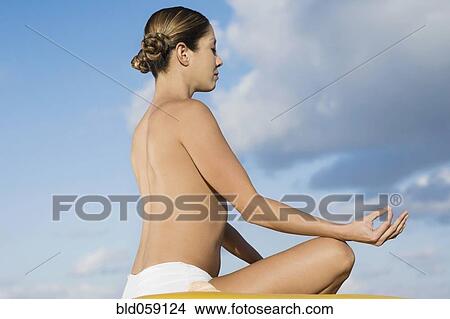 Picture - Topless Hispanic woman meditating. Fotosearch