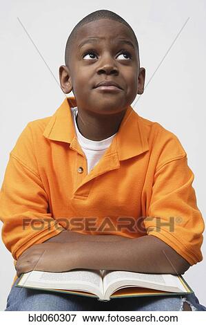 Stock Photo - African boy holding book. Fotosearch