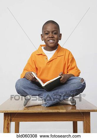 Stock Photo - African boy holding book. Fotosearch