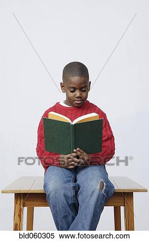 Stock Photography - African boy reading book. Fotosearch