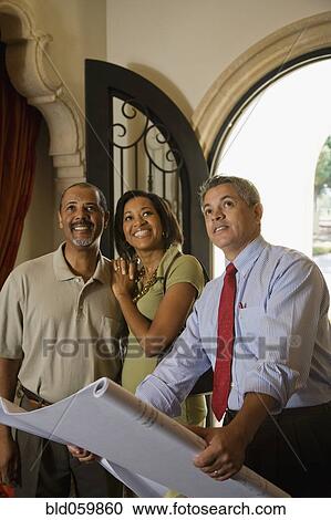 Stock Image - African couple looking at new house. Fotosearch