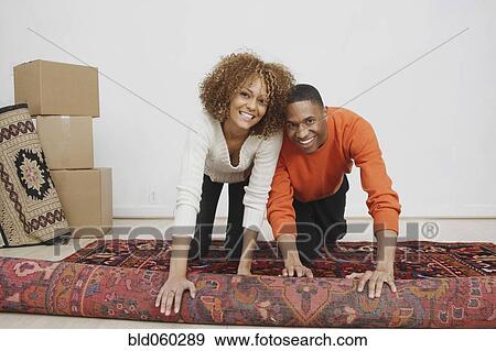 Stock Photo - African couple rolling rug. Fotosearch