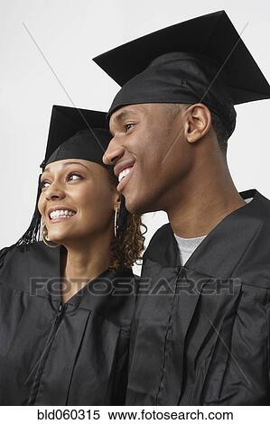 Stock Photography - African couple wearing graduation cap and gown. Fotosearch