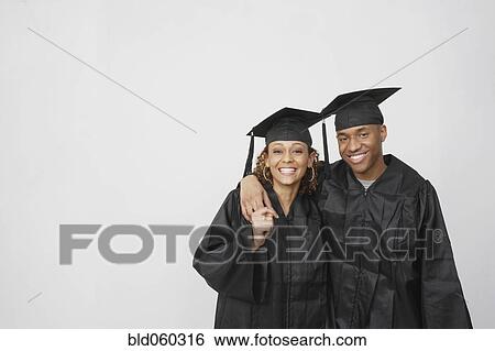 Stock Photograph - African couple wearing graduation caps and gowns. Fotosearch