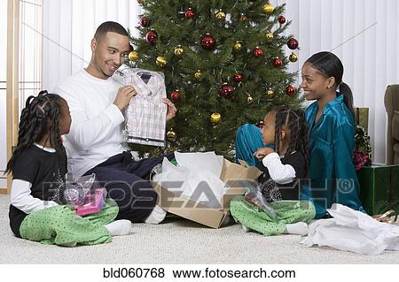 Stock Photo - African family opening Christmas gifts. Fotosearch