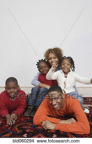 Picture - African family sitting on rug. Fotosearch