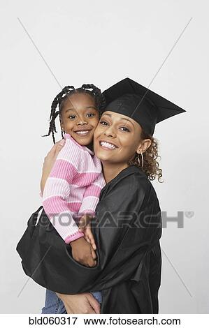 Stock Photo - African female graduate holding daughter. Fotosearch