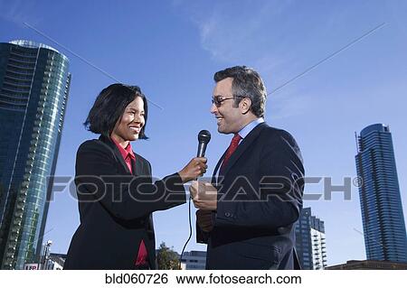 Stock Photograph - African female reporter interviewing businessman. Fotosearch