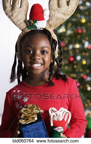 African girl holding Christmas gifts View Large Photo Image Picture - African girl holding Christmas gifts. Fotosearch