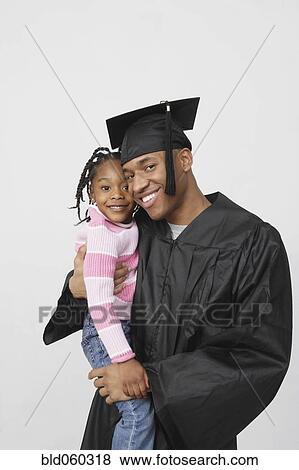 African male graduate holding daughter View Large Photo Image Stock Photo - African male graduate holding daughter. Fotosearch