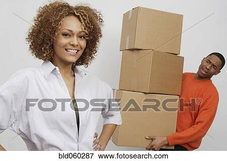Stock Photo - African man carrying moving boxes. Fotosearch