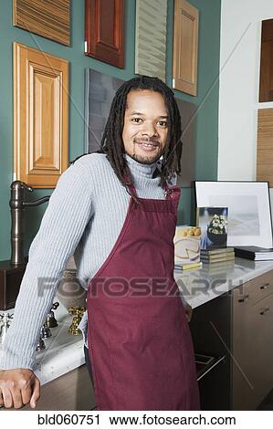 Stock Image - African sales clerk in home decor store. Fotosearch