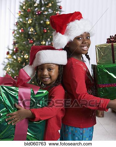 African sisters holding Christmas gifts View Large Photo Image Stock Image - African sisters holding Christmas gifts. Fotosearch