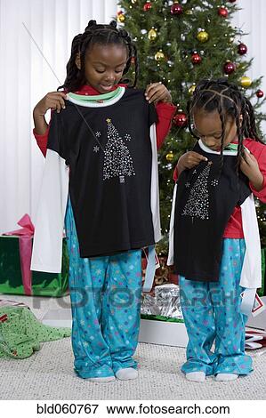 African sisters holding matching Christmas gifts View Large Photo Image Stock Photo - African sisters holding matching Christmas gifts. Fotosearch