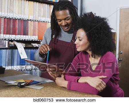 African woman and flooring sales clerk looking at clipboard View Large Photo Image Stock Image - African woman and flooring sales clerk looking at clipboard. Fotosearch