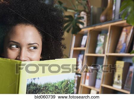 African woman looking over top of book View Large Photo Image Stock Photo - African woman looking over top of book. Fotosearch